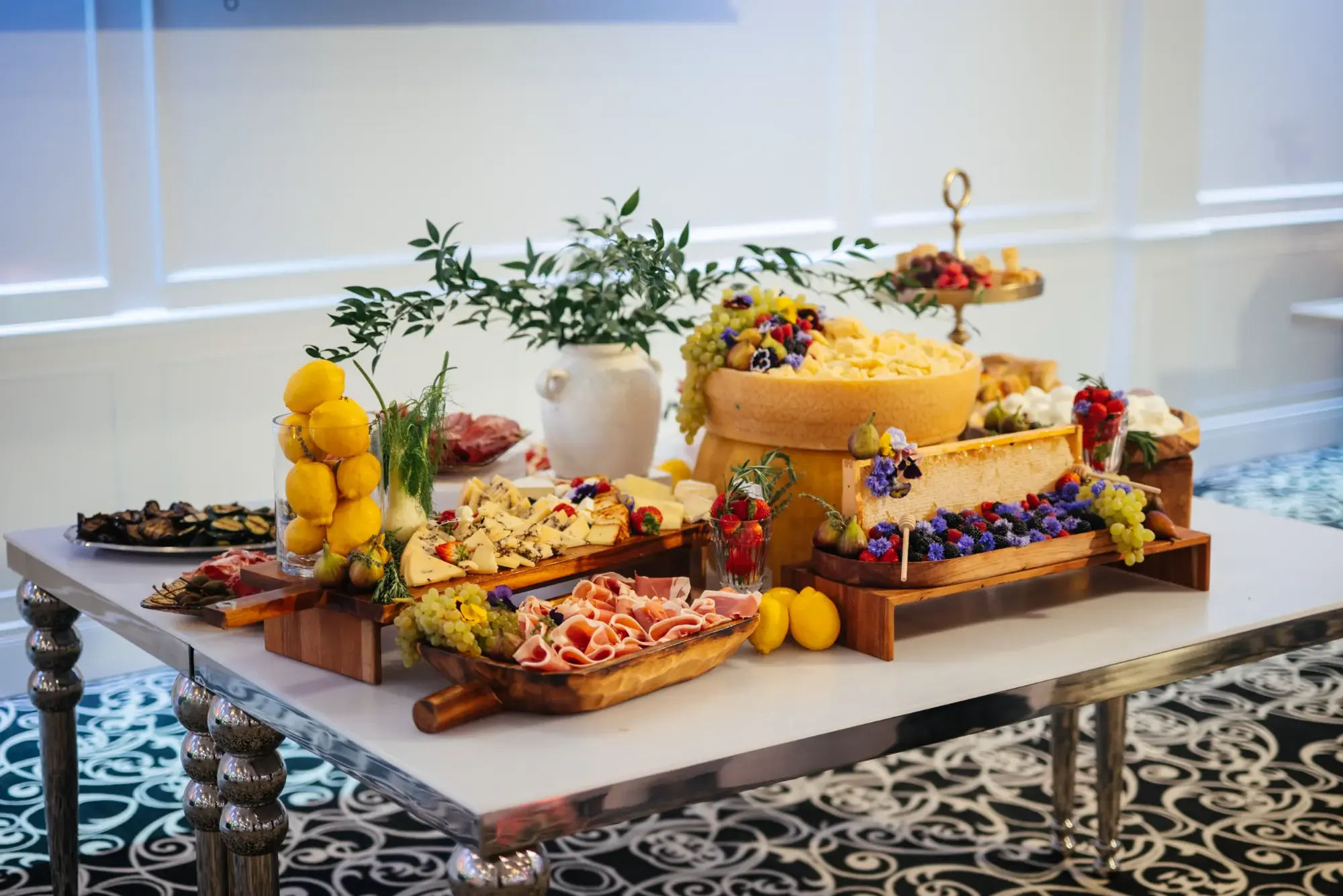 Buffet élégant composé de charcuteries, de fromages, de fruits et de rayons de miel.